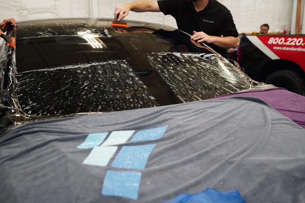 Windshield protection film being applied