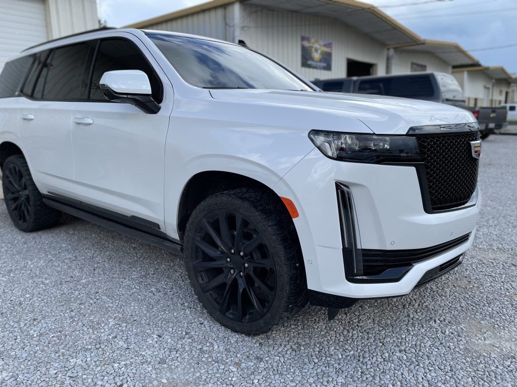 White Cadillac Escalade with chrome delete and blacked-out trim
