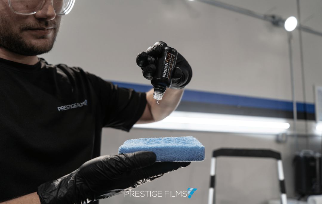 A detailer applying ceramic coating droplets to a application pad in Lafayette La.