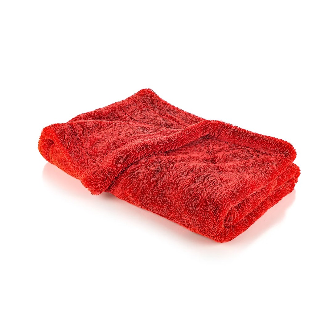 Red plush towel folded into a compact rectangle on a white background.