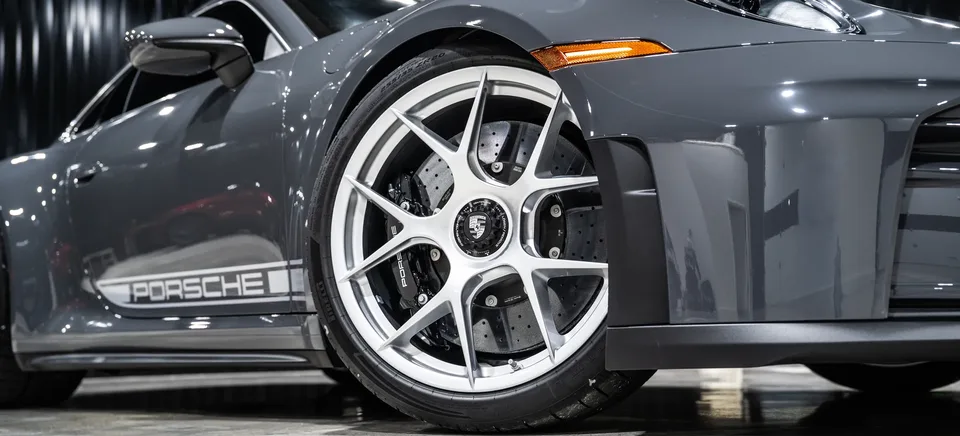 Gray Porsche 911 front wheel in the Prestige Films showroom