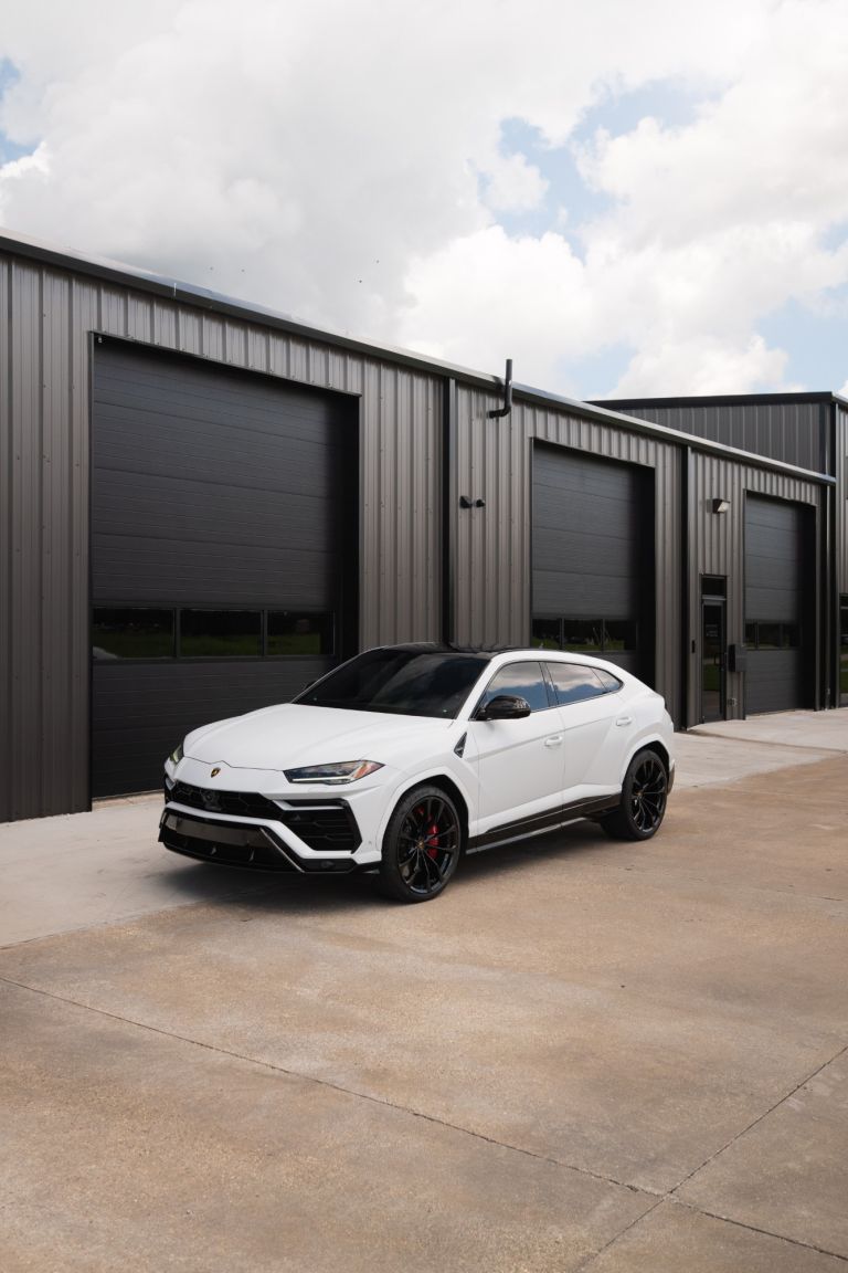 White Lamborghini Urus with paint protection film parked outside the Prestige Films shop
